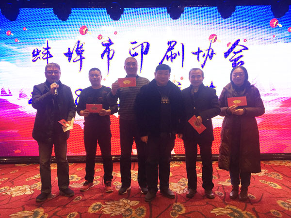 蚌埠市印刷協會副會長、蚌埠市興順彩印廠總經理周興平（中）登臺抽獎，并與獲獎人員合影留念