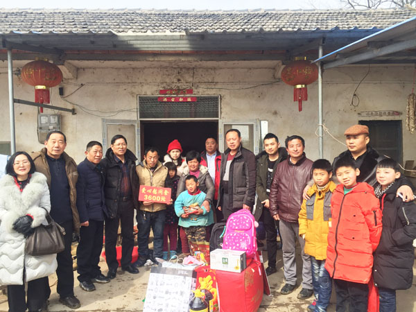 商會愛心慰問團正在張澤家全家（圖中），并與他們合影