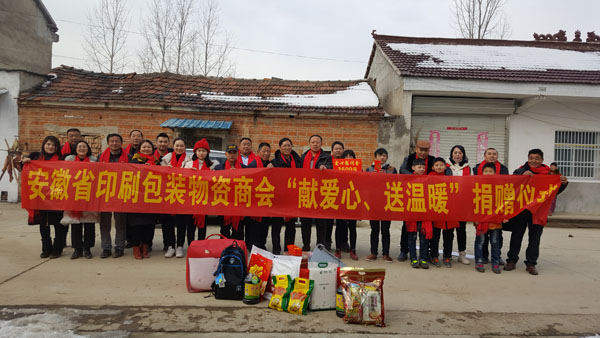 商會愛心尉問團正在慰問宋祝英母子（圖中），并與他們合影留念